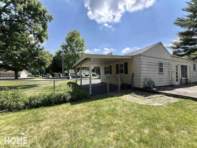 435 Brandon St, Owosso, MI 48867 - rear view of property with an attached carport, board and batten siding, a deck, and a chimney