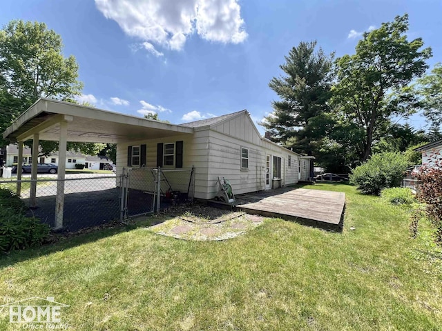 435 Brandon St, Owosso, MI 48867 - back of house with board and batten siding, a deck, and a carport