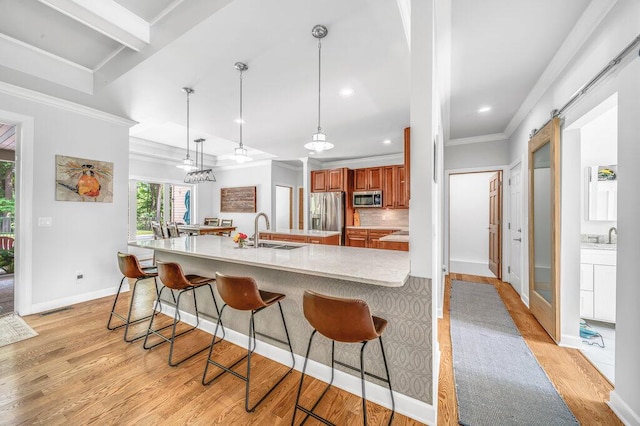 6143 Pheasant Ct, Berrien Springs, MI 49103 - kitchen featuring appliances with stainless steel finishes, brown cabinets, ornamental molding, light wood finished floors, and light countertops