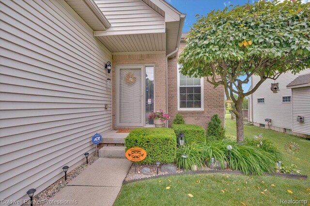 6087 Davison Rd, Byron, MI 48509 - entrance to property featuring brick siding and a lawn