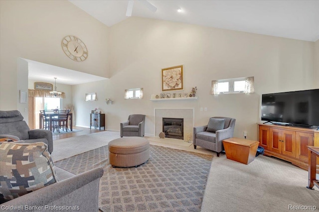6087 Davison Rd, Byron, MI 48509 - carpeted living area featuring a glass covered fireplace, high vaulted ceiling, and a chandelier