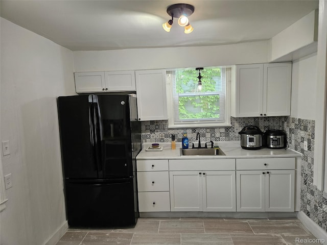 4294 W Buena Vista St, Detroit, MI 48238 - kitchen featuring freestanding refrigerator, light countertops, white cabinetry, and backsplash
