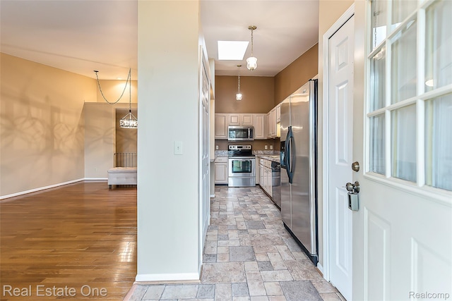 62622 Raleigh Ct Unit 4, South Lyon, MI 48178 - kitchen featuring stainless steel appliances, light countertops, pendant lighting, and light stone finish flooring