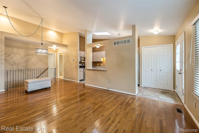 62622 Raleigh Ct Unit 4, South Lyon, MI 48178 - unfurnished living room featuring wood-type flooring and baseboards