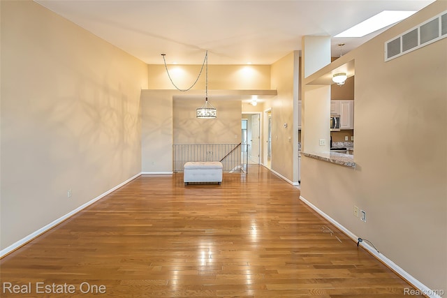 62622 Raleigh Ct Unit 4, South Lyon, MI 48178 - empty room with hardwood / wood-style floors and a skylight