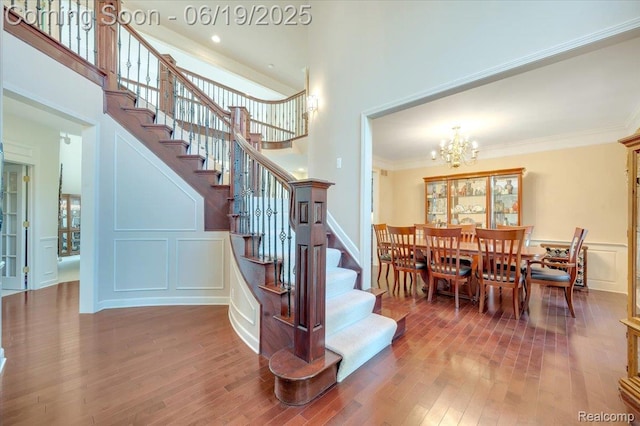 43443 Mclean Ct, Novi, MI 48375 - stairs featuring a chandelier, wood finished floors, crown molding, healthy amount of natural light, and a decorative wall