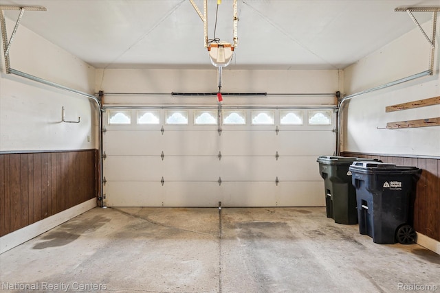 13142 Boca Grande Dr, Sterling Heights, MI 48312 - garage featuring a garage door opener, wooden walls, and wainscoting