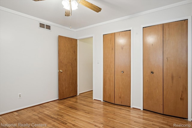 13142 Boca Grande Dr, Sterling Heights, MI 48312 - unfurnished bedroom with multiple closets, wood finished floors, ornamental molding, and ceiling fan