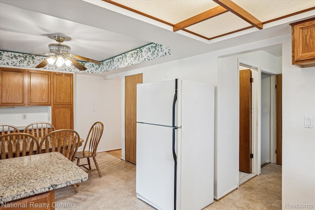 13142 Boca Grande Dr, Sterling Heights, MI 48312 - kitchen with freestanding refrigerator, ceiling fan, light floors, brown cabinets, and light stone counters