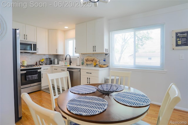 14839 Chippewa Dr, Warren, MI 48088 - kitchen featuring stainless steel appliances, decorative backsplash, white cabinetry, and light wood finished floors
