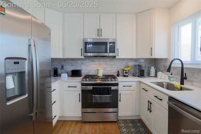 14839 Chippewa Dr, Warren, MI 48088 - kitchen with stainless steel appliances, light countertops, tasteful backsplash, and white cabinets
