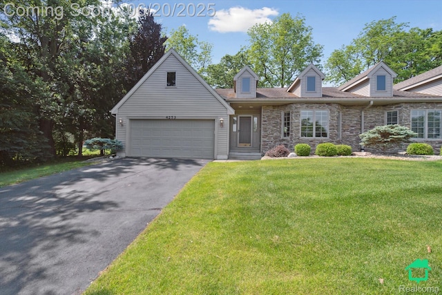 4273 Fairway Ln, Jackson, MI 49201 - cape cod house with stone siding, driveway, a front yard, and an attached garage