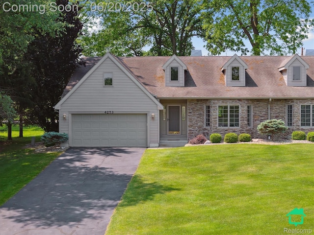 4273 Fairway Ln, Jackson, MI 49201 - new england style home featuring asphalt driveway, a front yard, stone siding, and roof with shingles