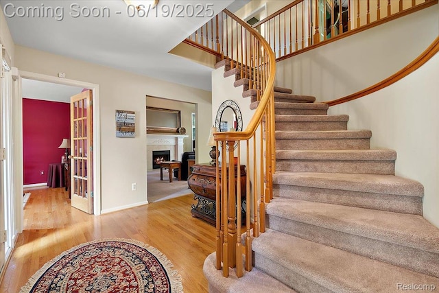 2082 Avon Lake Ln, Rochester Hills, MI 48307 - stairs featuring a lit fireplace and wood finished floors