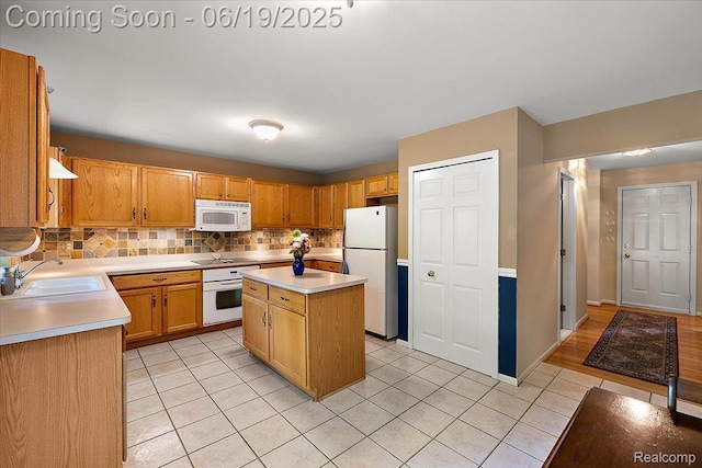2082 Avon Lake Ln, Rochester Hills, MI 48307 - kitchen with white appliances, light countertops, light tile patterned floors, decorative backsplash, and a center island