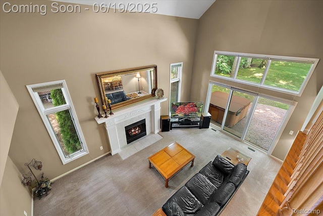 2082 Avon Lake Ln, Rochester Hills, MI 48307 - living area with a towering ceiling, carpet floors, a fireplace with flush hearth, and healthy amount of natural light