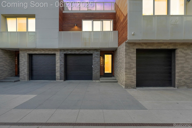 2648 John R St, Detroit, MI 48201 - contemporary home featuring an attached garage, concrete driveway, and brick siding