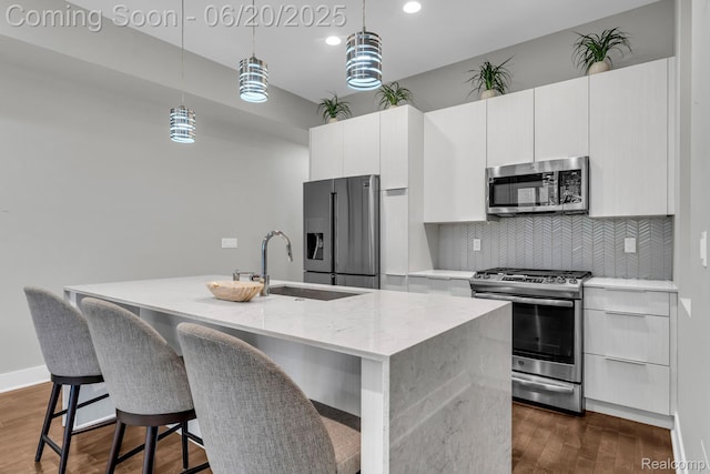 2648 John R St, Detroit, MI 48201 - kitchen with stainless steel appliances, a center island with sink, backsplash, dark wood-type flooring, and hanging light fixtures