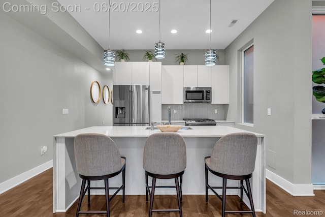 2648 John R St, Detroit, MI 48201 - kitchen featuring appliances with stainless steel finishes, white cabinetry, a center island with sink, tasteful backsplash, and light countertops