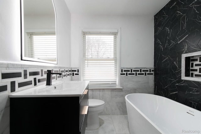 15821 Kentfield St, Detroit, MI 48223 - bathroom featuring tile walls, healthy amount of natural light, a freestanding tub, vanity, and an accent wall
