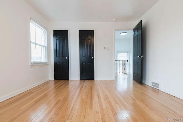 15821 Kentfield St, Detroit, MI 48223 - unfurnished bedroom featuring light wood-type flooring, multiple windows, and multiple closets