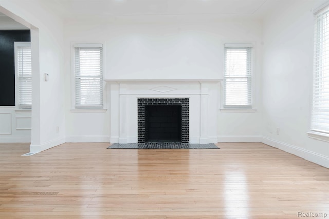 15821 Kentfield St, Detroit, MI 48223 - unfurnished living room featuring light wood-type flooring, a fireplace, and plenty of natural light