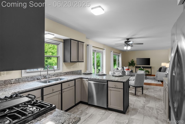 2206 Estates Dr, Highland, MI 48357 - kitchen with appliances with stainless steel finishes, a peninsula, gray cabinetry, ceiling fan, and open floor plan