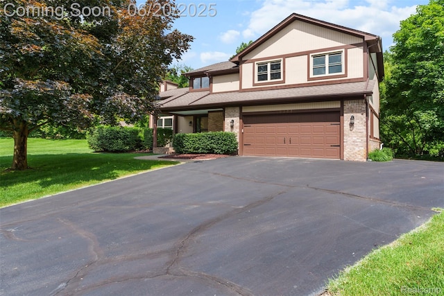 2206 Estates Dr, Highland, MI 48357 - view of front facade with driveway, a garage, brick siding, and a front yard