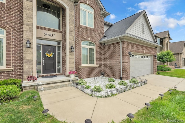 50432 Maywood, Dearborn, MI 48188 - view of exterior entry with brick siding, concrete driveway, and an attached garage