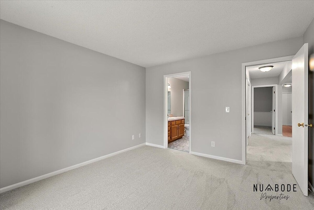 1427 Atlantic St NW, Grand Rapids, MI 49504 - unfurnished bedroom featuring light colored carpet, a textured ceiling, and ensuite bath