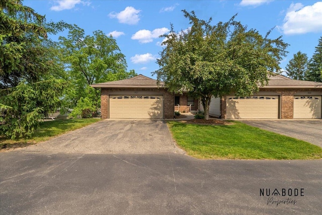 1427 Atlantic St NW, Grand Rapids, MI 49504 - view of front facade with brick siding, asphalt driveway, a garage, and a front lawn