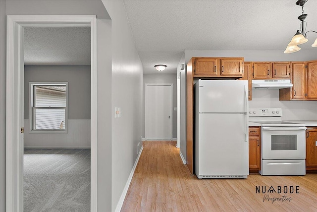 1427 Atlantic St NW, Grand Rapids, MI 49504 - kitchen with white appliances, under cabinet range hood, a textured ceiling, decorative light fixtures, and light wood-style flooring