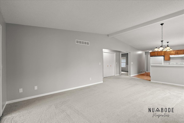 1427 Atlantic St NW, Grand Rapids, MI 49504 - unfurnished living room with a chandelier, light colored carpet, and a textured ceiling