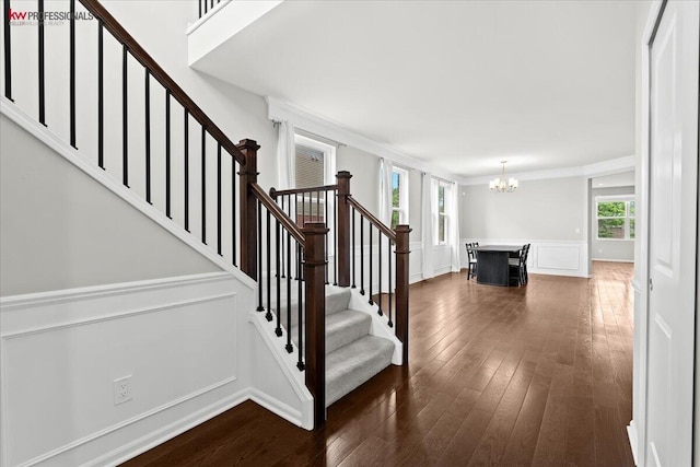 945 Reef Dr, Canton, MI 48187 - stairway featuring a decorative wall, a chandelier, wood finished floors, ornamental molding, and a wainscoted wall