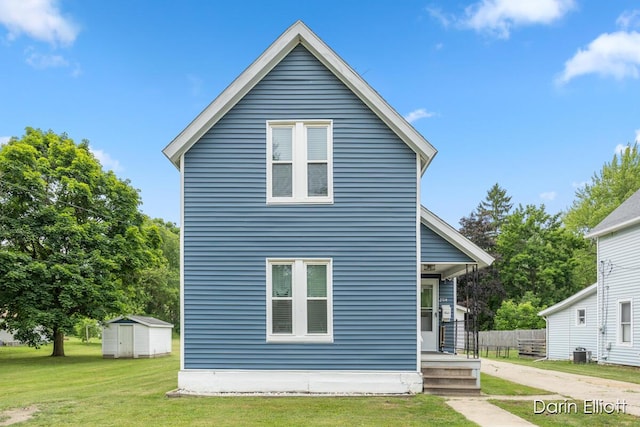 204 Maple St, Durand, MI 48429 - view of front of house featuring a shed, a front yard, and covered porch
