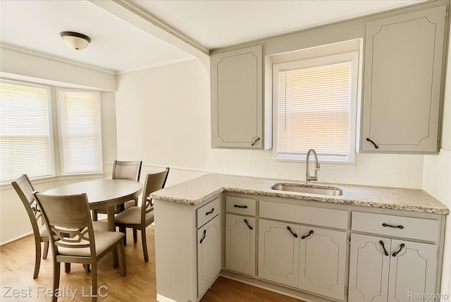 15684 Manning St, Detroit, MI 48205 - kitchen featuring light wood finished floors, light countertops, a peninsula, and ornamental molding