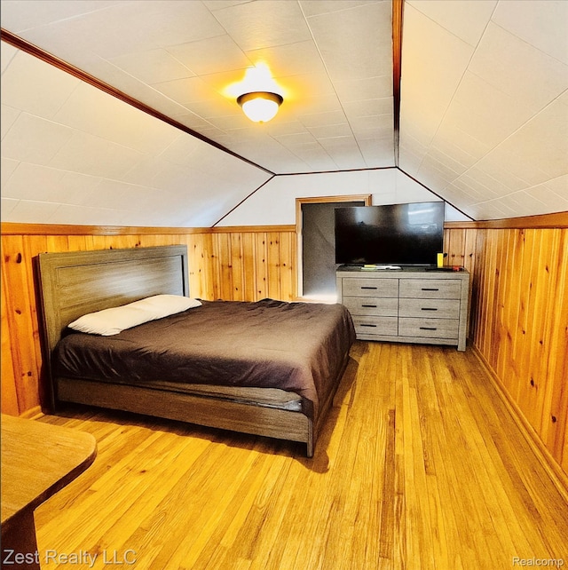 15684 Manning St, Detroit, MI 48205 - bedroom with wood walls, light wood-style flooring, and lofted ceiling