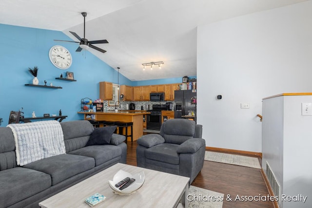1300 Lancaster Ave NW, Grand Rapids, MI 49504 - living area featuring dark wood-type flooring, vaulted ceiling, and ceiling fan