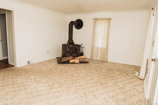 8667 Thompson Hwy, Blissfield, MI 49228 - unfurnished living room with carpet flooring and a wood stove