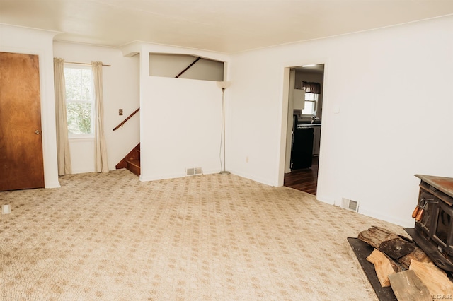 8667 Thompson Hwy, Blissfield, MI 49228 - living room featuring a wood stove, plenty of natural light, stairway, and carpet