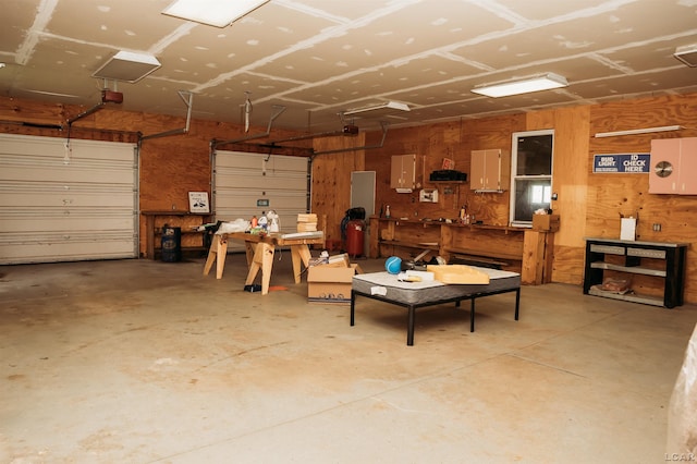8667 Thompson Hwy, Blissfield, MI 49228 - garage with a workshop area, wooden walls, and a garage door opener