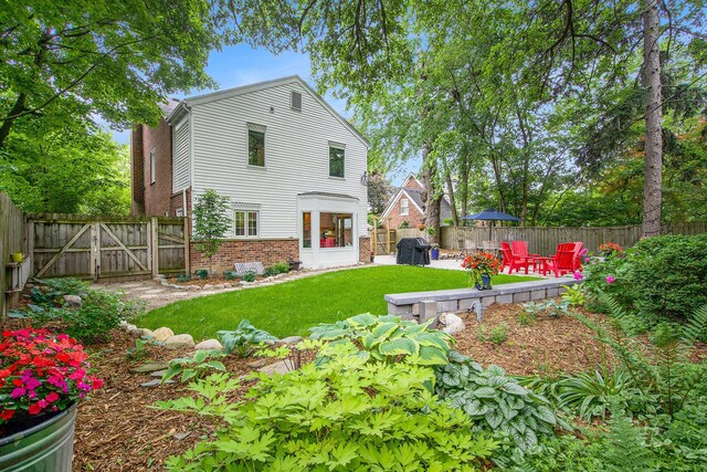 1515 E Stadium Blvd, Ann Arbor, MI 48104 - back of property with brick siding, a gate, a patio area, and a fenced backyard
