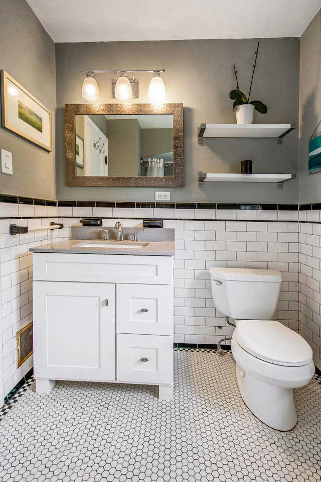 1515 E Stadium Blvd, Ann Arbor, MI 48104 - bathroom with tile walls, vanity, tile patterned floors, and wainscoting