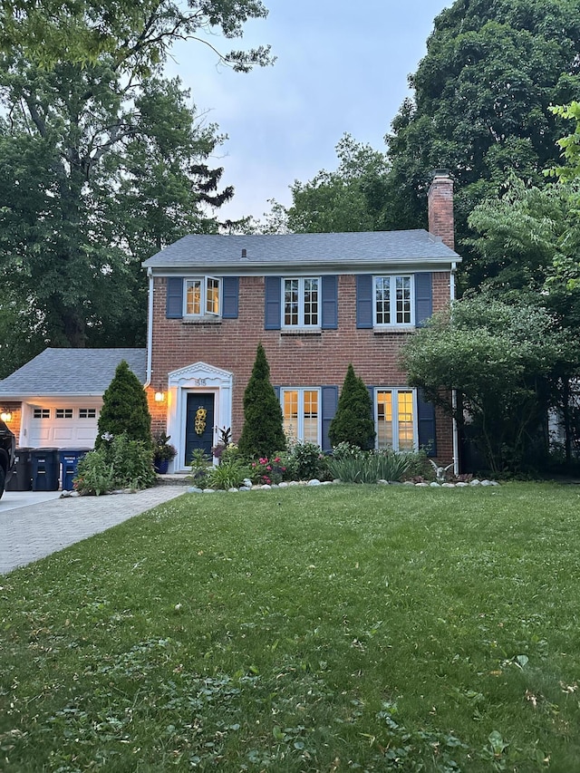 1515 E Stadium Blvd, Ann Arbor, MI 48104 - colonial inspired home with a chimney, an attached garage, a front lawn, and brick siding