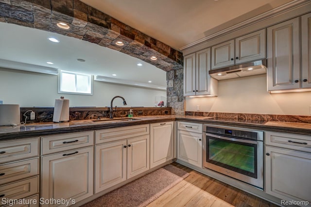 3225 Legacy Ct, West Bloomfield, MI 48323 - kitchen featuring stainless steel oven, under cabinet range hood, dark countertops, black electric stovetop, and light wood-type flooring