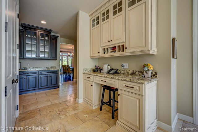 3225 Legacy Ct, West Bloomfield, MI 48323 - kitchen with cream cabinetry, built in study area, light stone countertops, and recessed lighting