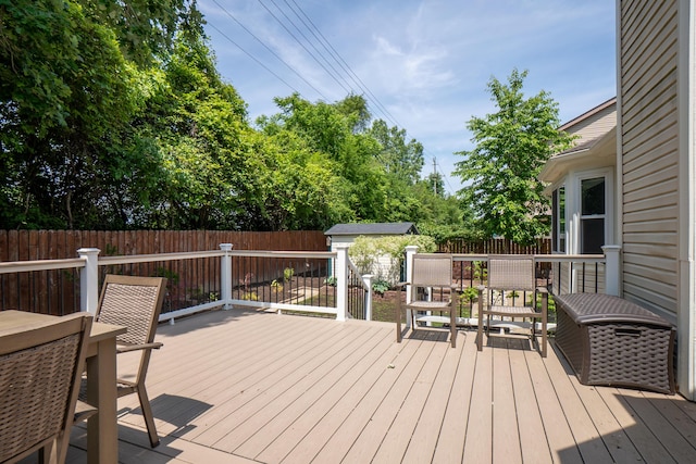 4351 Knollcrest Dr, Ann Arbor, MI 48108 - wooden terrace featuring a fenced backyard, outdoor dining area, and a storage unit