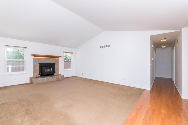 4351 Knollcrest Dr, Ann Arbor, MI 48108 - unfurnished living room with lofted ceiling, a tile fireplace, light carpet, and light wood finished floors