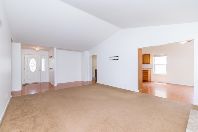 4351 Knollcrest Dr, Ann Arbor, MI 48108 - unfurnished living room with light carpet, plenty of natural light, and vaulted ceiling