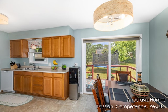 4516 Burgis Ave SE, Grand Rapids, MI 49508 - kitchen featuring white dishwasher, light countertops, and brown cabinets